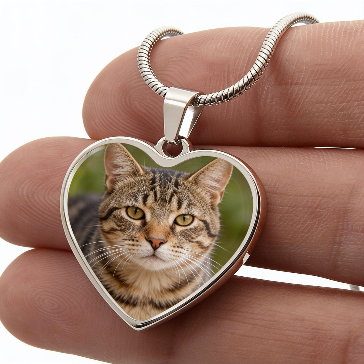 Collier pendentif cœur acier tenu à la main, photo de chat